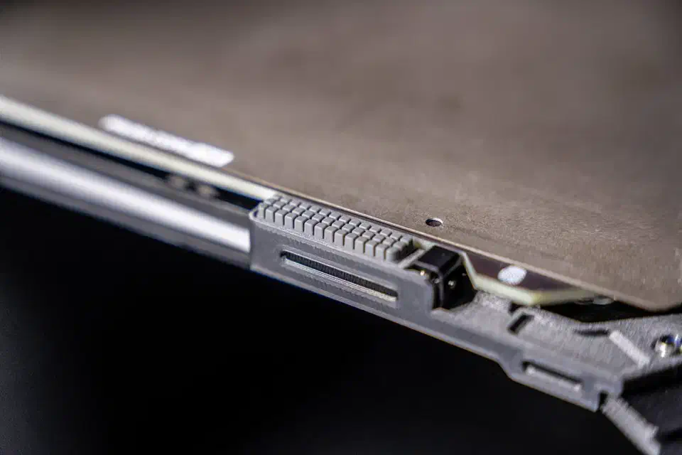 Ridged grey silicone nozzle wiper consumable mounted along the front edge of the Prusa XL+ heatbed